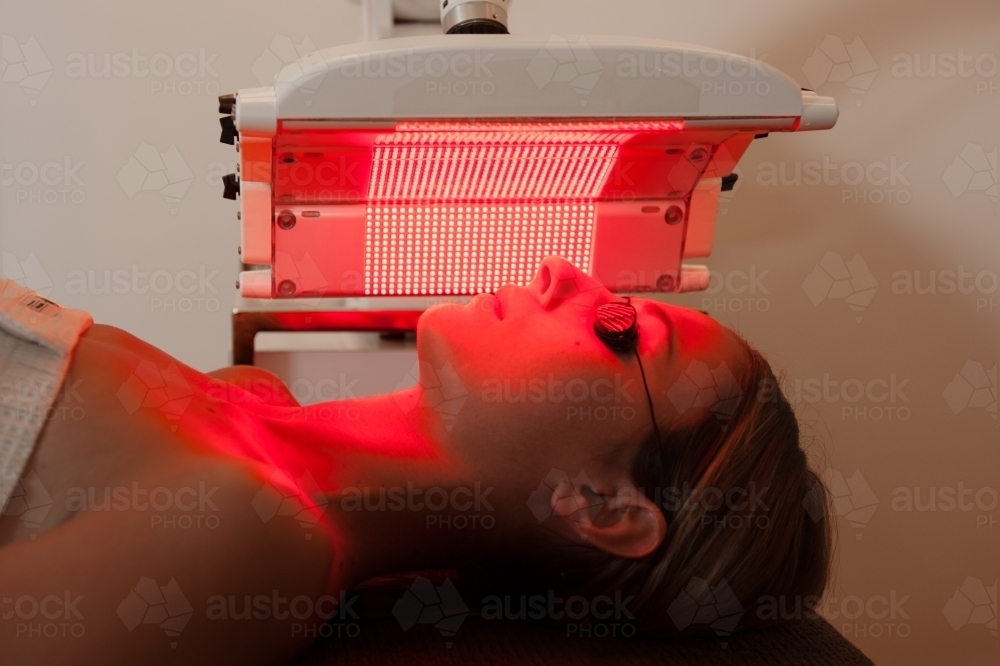 woman having beauty treatment, light therapy session, red light - Australian Stock Image