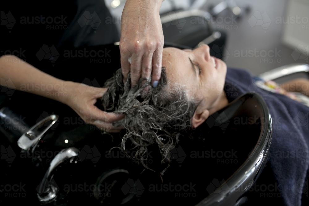 Woman having hair washed at hairdressing salon - Australian Stock Image