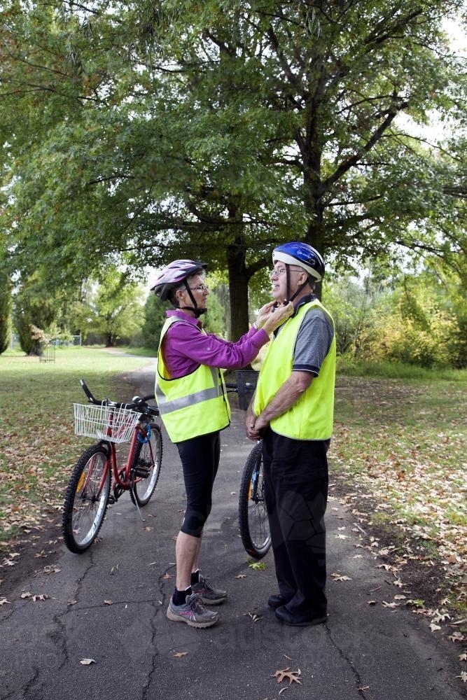 Woman helping disabled man with bike helmet - Australian Stock Image