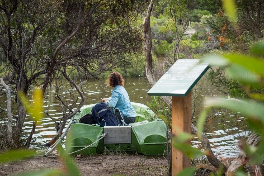 Woman hiking Kangaroo Island Wilderness Trail sitting in boat - Australian Stock Image
