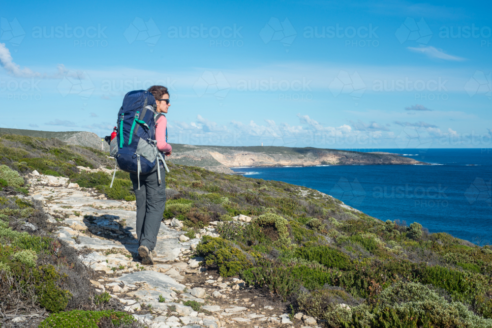 Woman hiking Kangaroo Island Wilderness Trail with backpack near ocean - Australian Stock Image