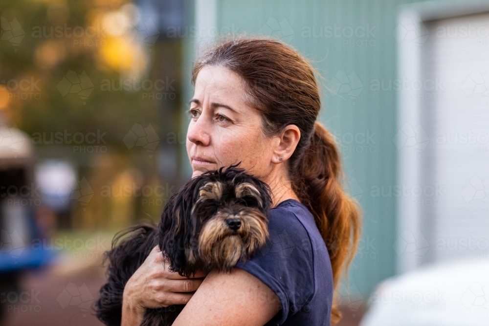 Woman holding little dog head and shoulders - Australian Stock Image