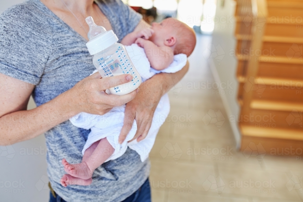 Woman holding newborn and bottle - Australian Stock Image