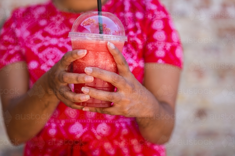 woman holding pink smoothie drink - Australian Stock Image