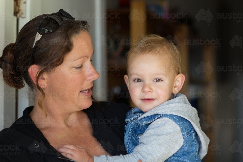 Woman holding toddler at home - Australian Stock Image