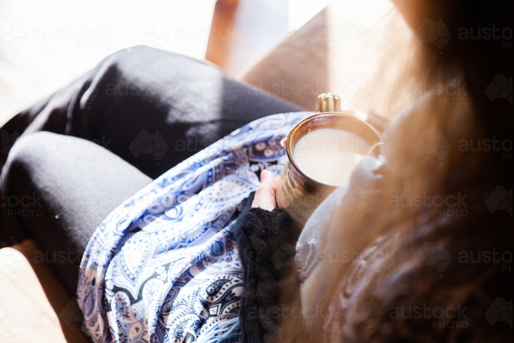 Woman holding warm mug of chai tea in winter - Australian Stock Image