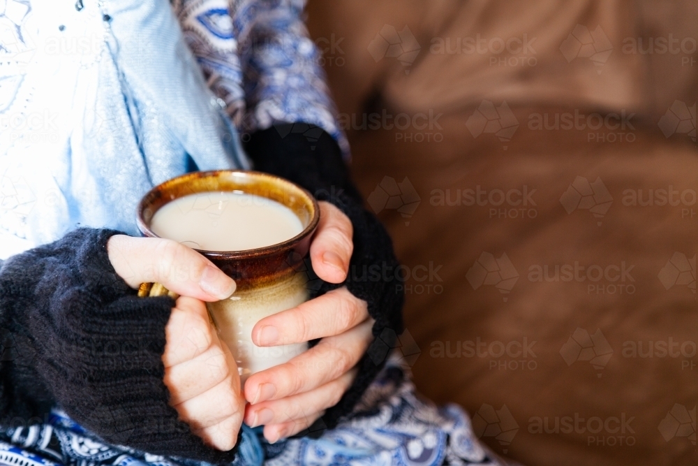 Woman holding warm mug of chai tea in winter - Australian Stock Image