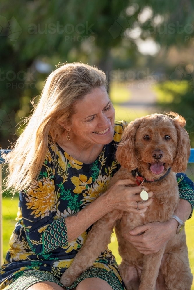 Woman hugging her pet dog at a park - Australian Stock Image