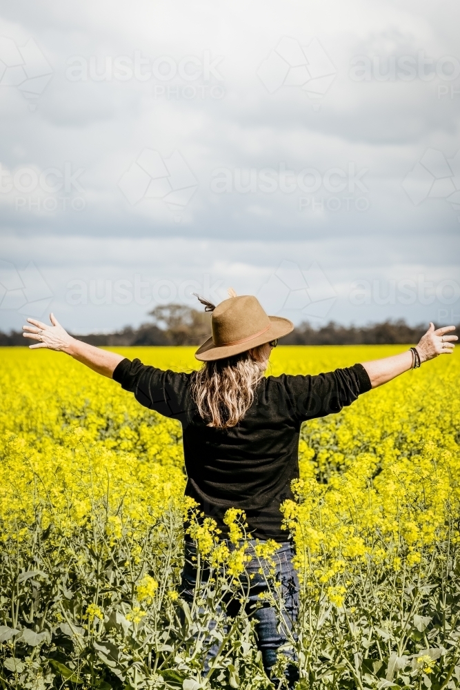 Woman in a canola field - Australian Stock Image