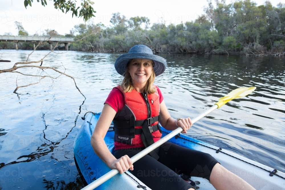 woman in canoe looking at camera - Australian Stock Image