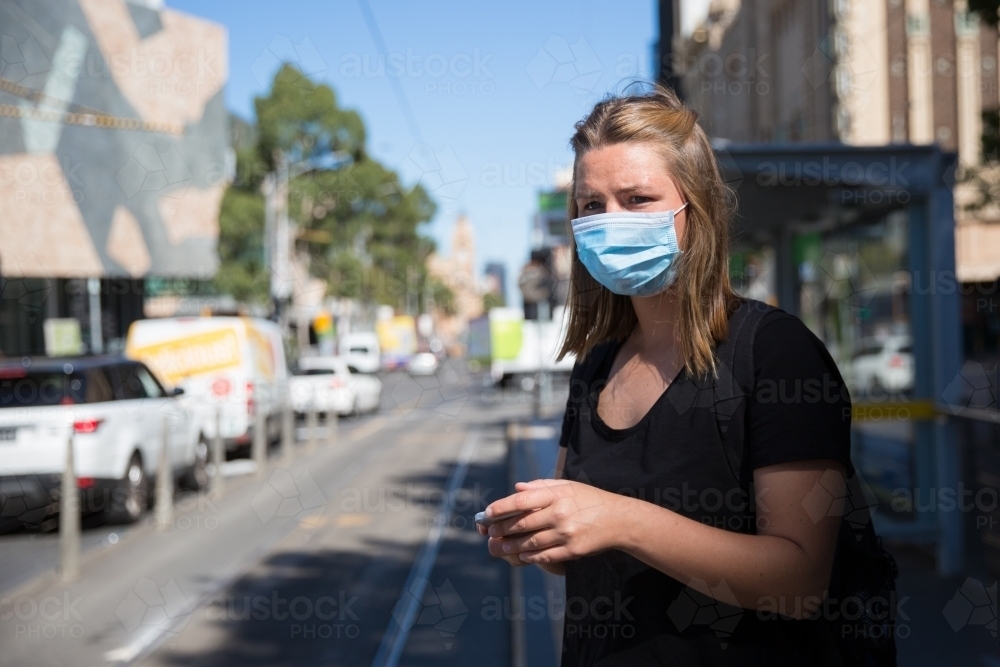 Woman in Face Mask Waiting for Public Transport - Australian Stock Image