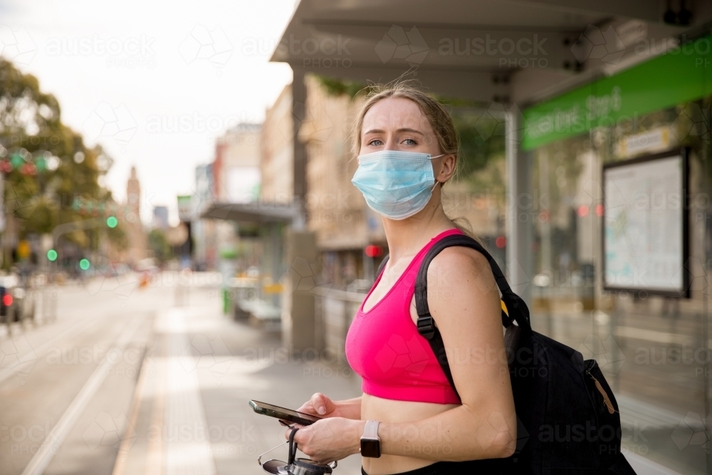 Woman in Face Mask Waiting for Tram - Australian Stock Image