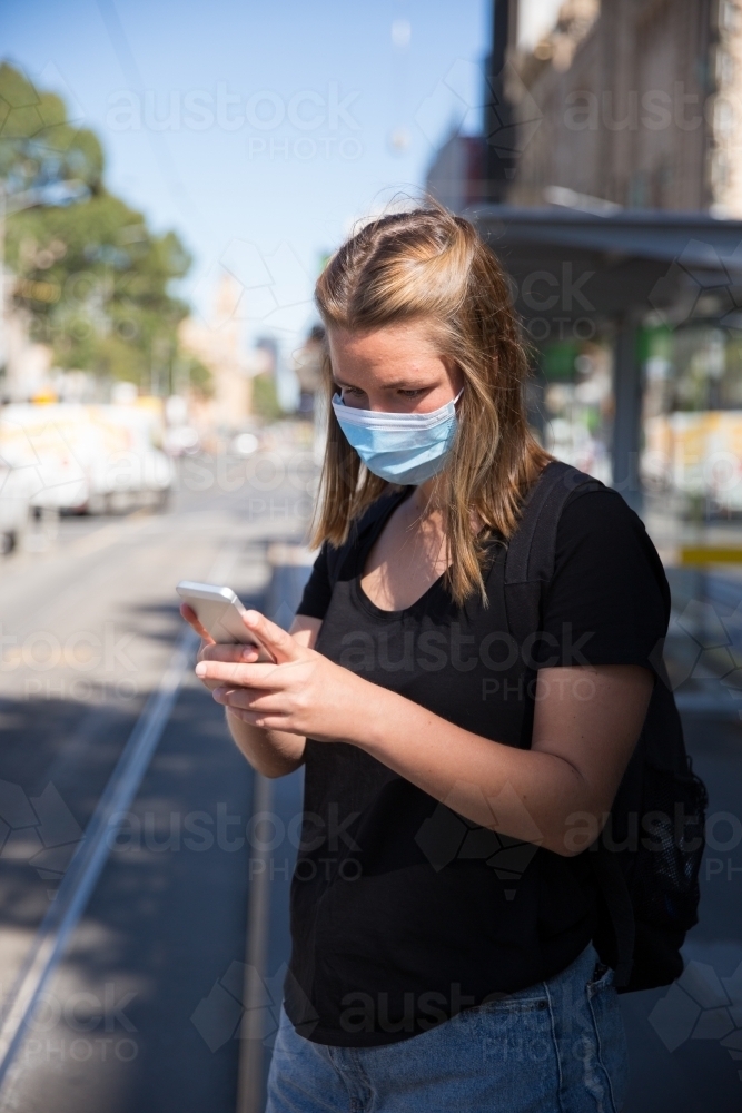 Woman in Face Mask Waiting for Transport - Australian Stock Image