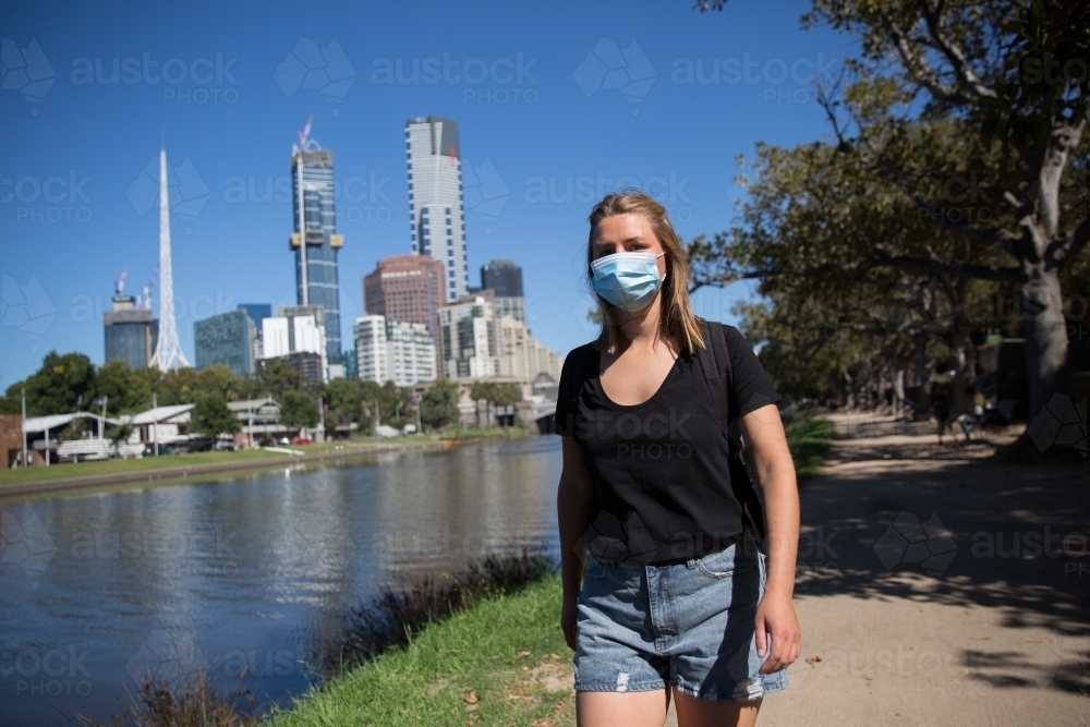 Woman in Face Mask Walking by the Yarra - Australian Stock Image