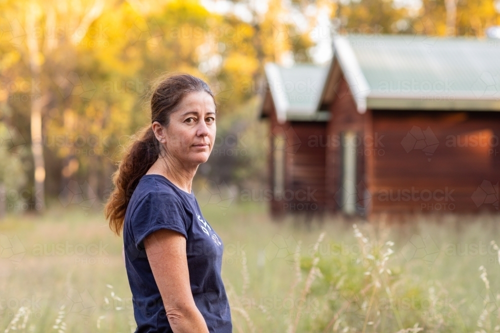 woman in the country outside timber house - Australian Stock Image