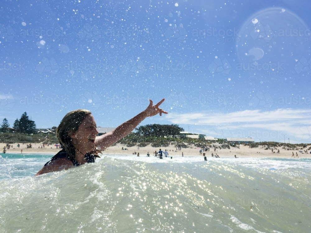 Woman in the ocean signalling positive attitude - Australian Stock Image