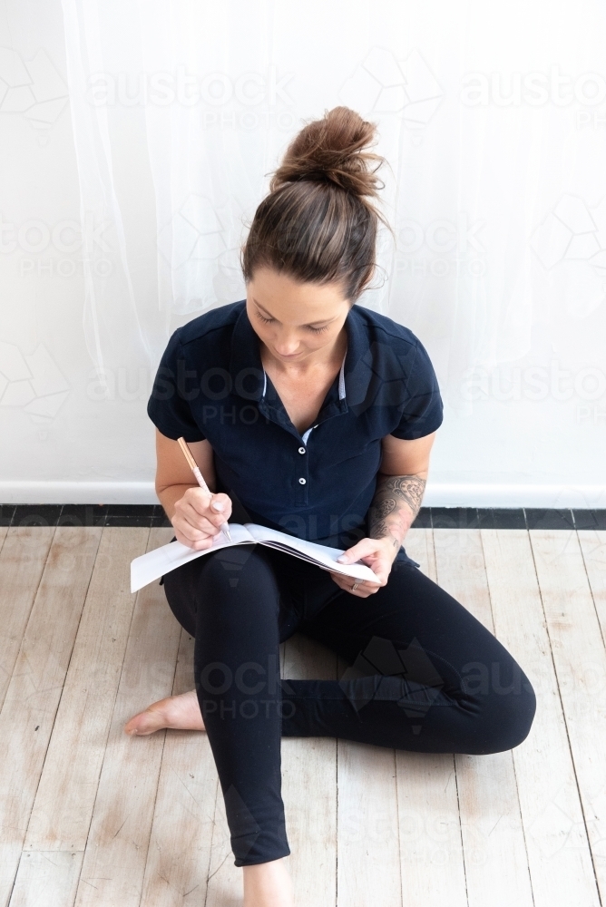 woman in yoga clothes journalling - Australian Stock Image