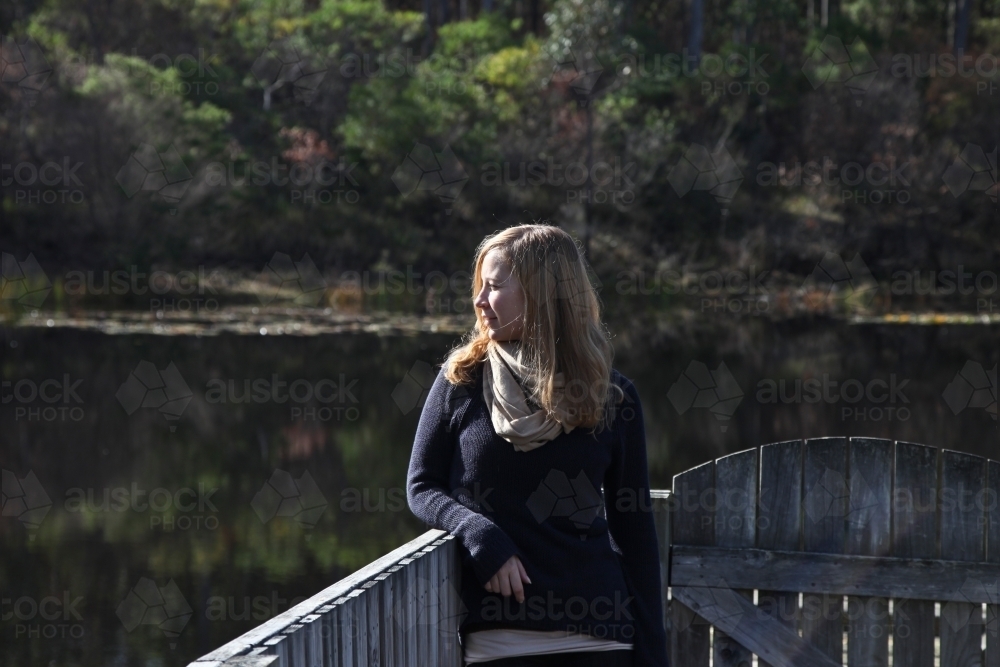 Woman leaning on fence the river - Australian Stock Image