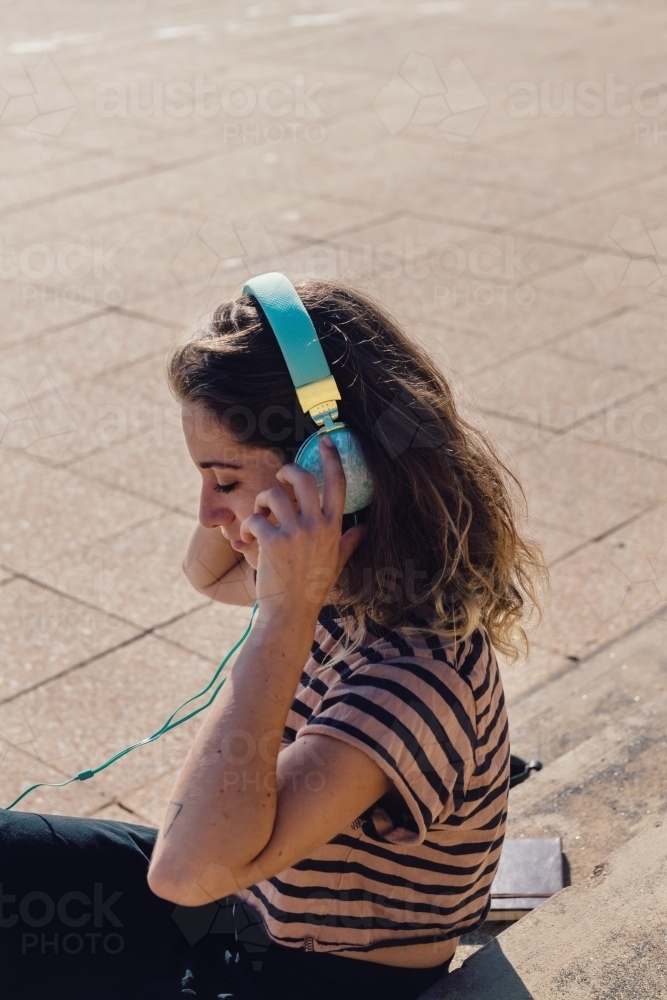woman listening to music outdoors - Australian Stock Image