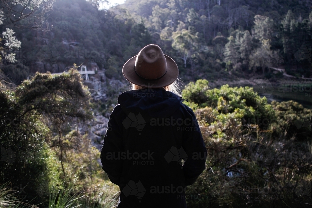 Woman looking out over Cataract Gorge wearing hat and jacket - Australian Stock Image