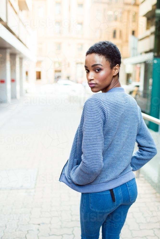 Woman looking over her shoulder walking away - Australian Stock Image