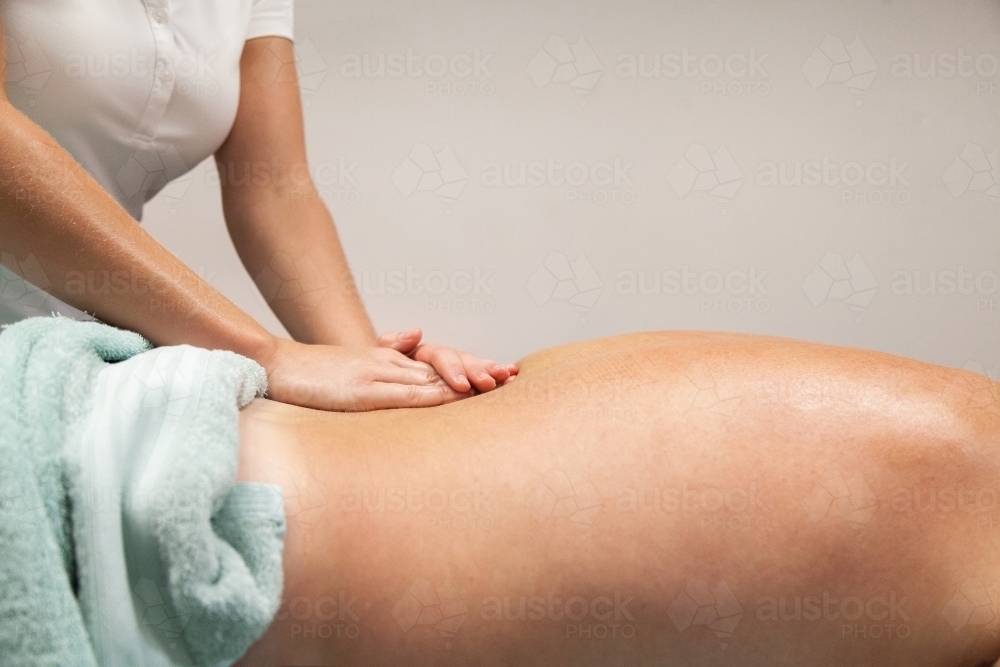 Woman massaging man's back in physio clinic - Australian Stock Image