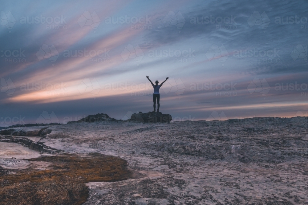 Woman on rock with arm outstretched Lincoln's Rock Kings Tableland. - Australian Stock Image