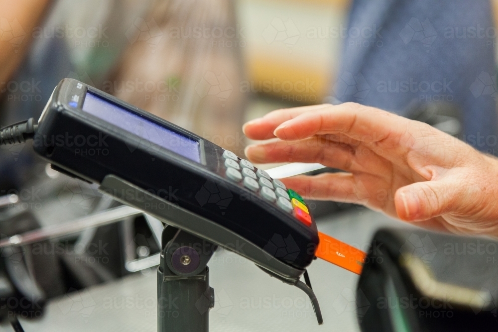 Woman paying for shopping with visa debit card at supermarket - Australian Stock Image