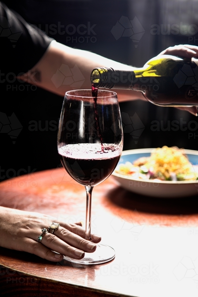Woman pouring a glass of red wine - Australian Stock Image
