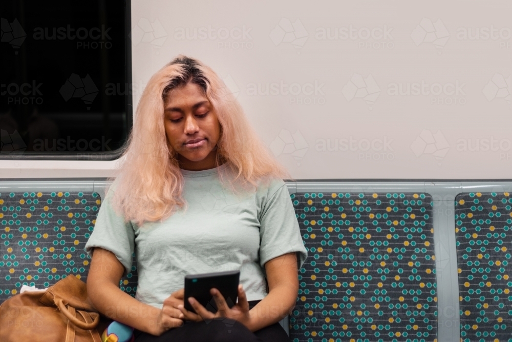 woman reading ebook on a train - Australian Stock Image
