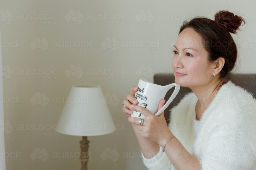 Woman relaxing and drinking tea at home - Australian Stock Image