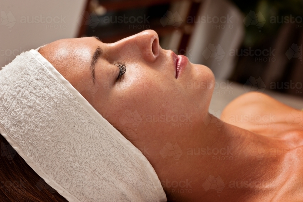Woman relaxing in soft light at a beauty salon - Australian Stock Image