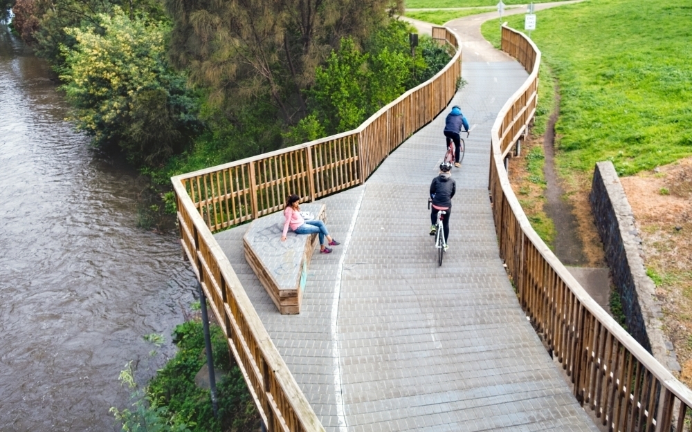 Woman relaxing on a bench on Merri Creek Trail - Australian Stock Image