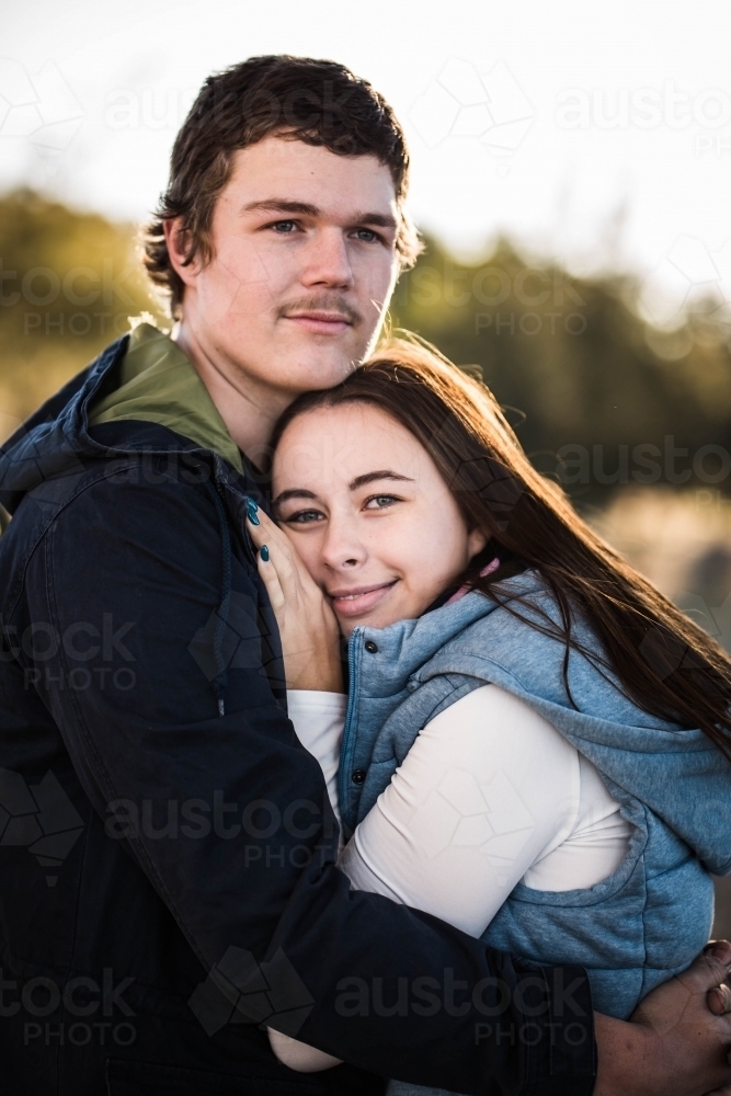 Woman resting head on boyfriend's chest while he looks into distance - Australian Stock Image
