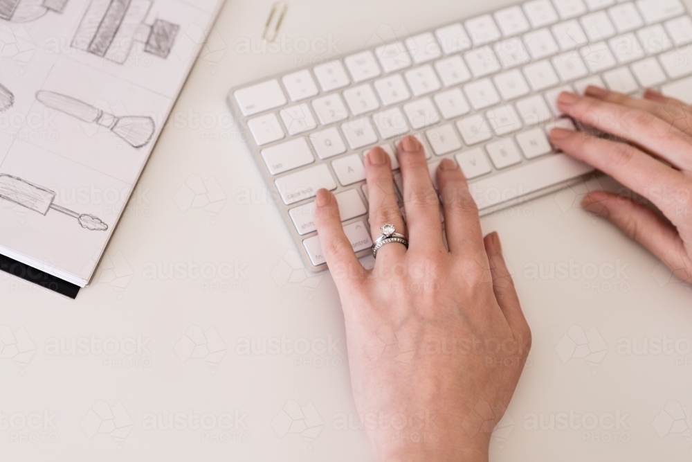 woman's hands on keyboard, with wedding ring - Australian Stock Image