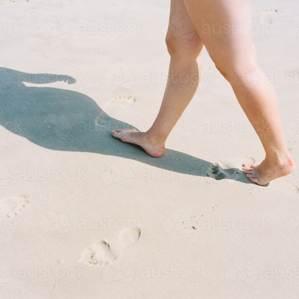 Woman's Legs walking through sand - Australian Stock Image