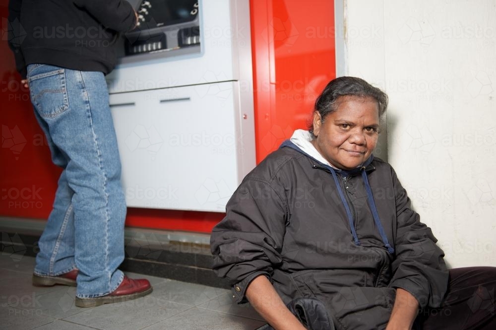 Woman seated near ATM - Australian Stock Image