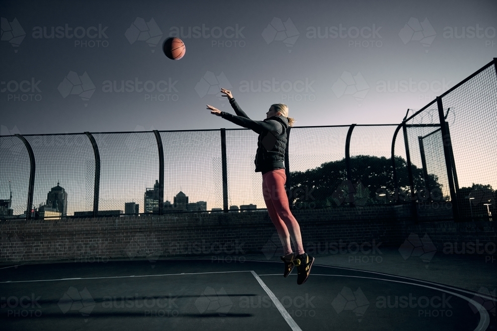 Woman Shooting basketball on court - Australian Stock Image