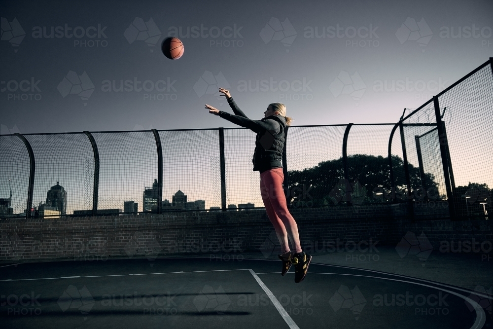 Woman Shooting basketball on court - Australian Stock Image