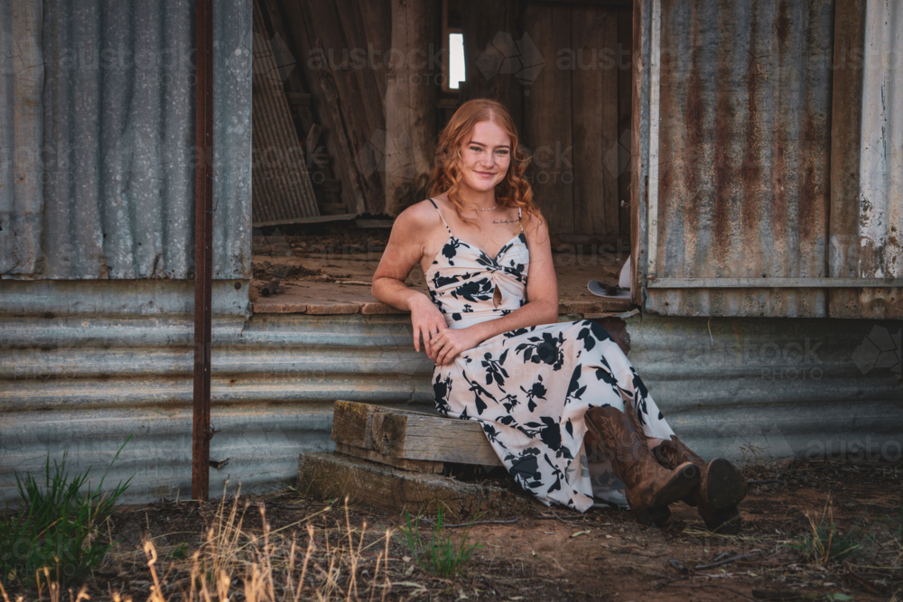 Woman sitting by a shearing shed - Australian Stock Image