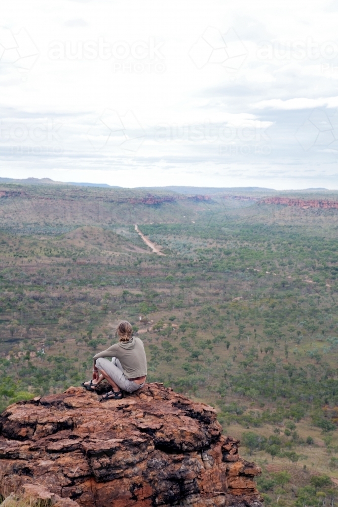 Woman sitting on clifftop in outback Australia - Australian Stock Image