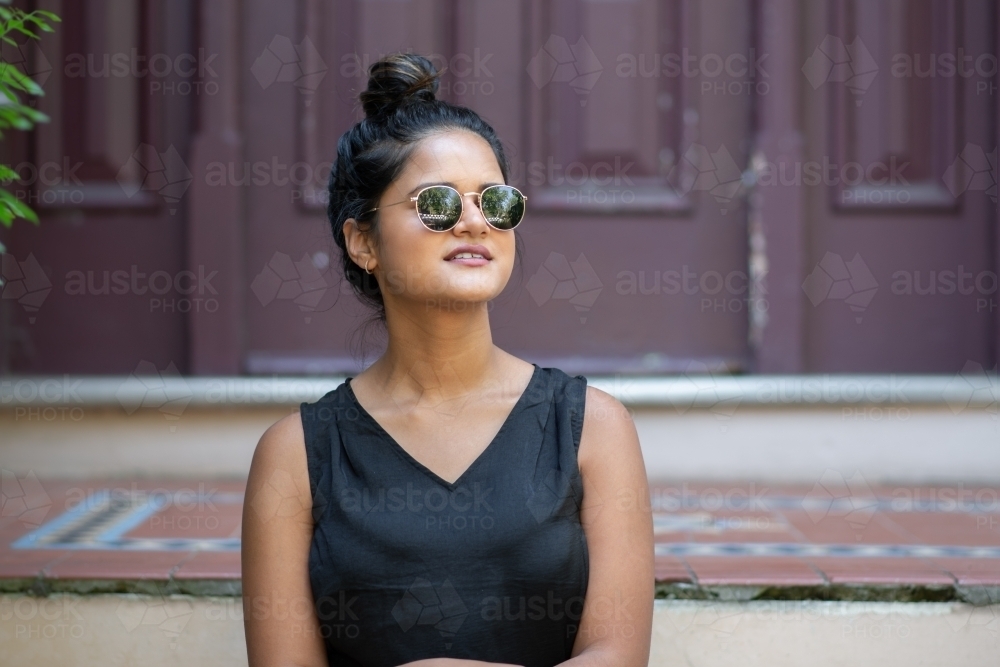 woman sitting outside front door of house - Australian Stock Image