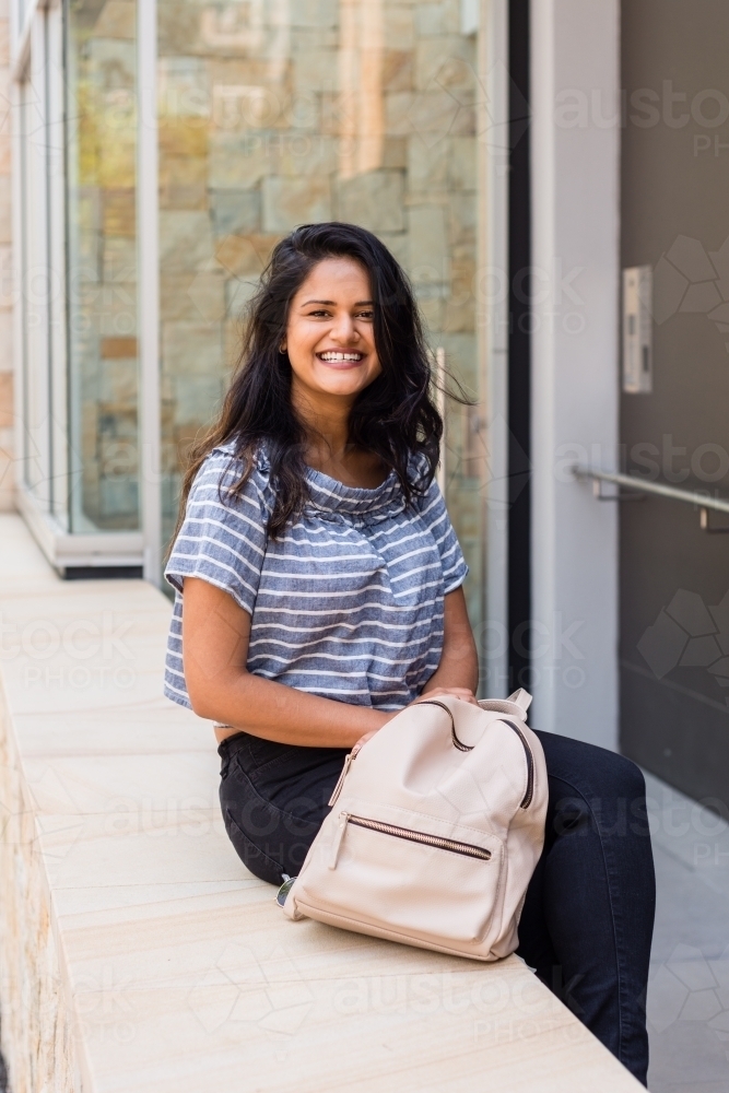 woman sitting outside modern building - Australian Stock Image