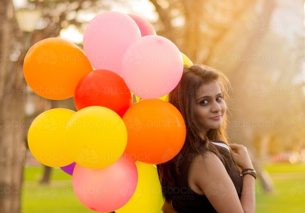 Woman smiling and holding balloons - Australian Stock Image