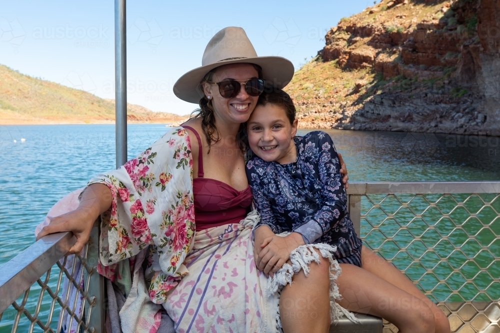 Woman smiling with arm around young girl on a boat cruise - Australian Stock Image