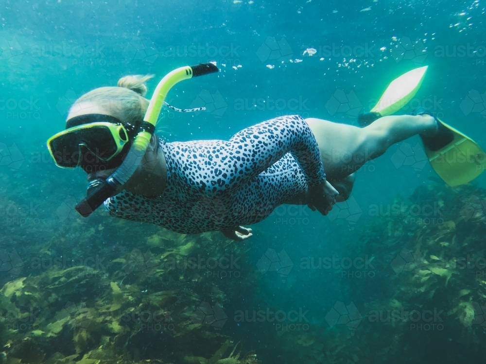 Woman snorkelling over reef and coral - Australian Stock Image