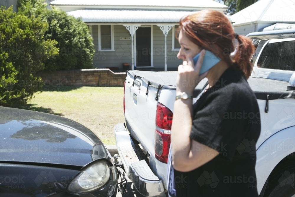 Woman standing beside car accident - Australian Stock Image