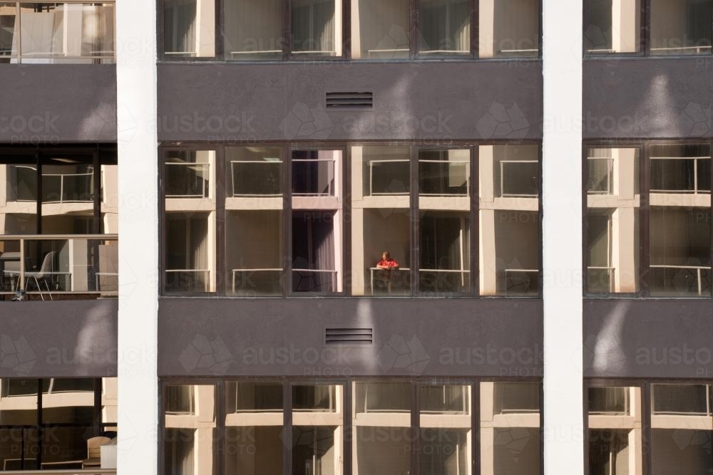 Woman standing on the balcony of a high rise apartment : Austockphoto Woman standing on the balcony of a high rise apartment - Australian Stock Image