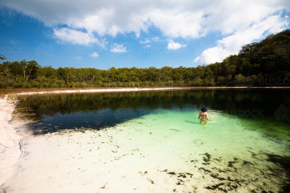 Woman swimming in a secluded lake on Fraser Island - Australian Stock Image