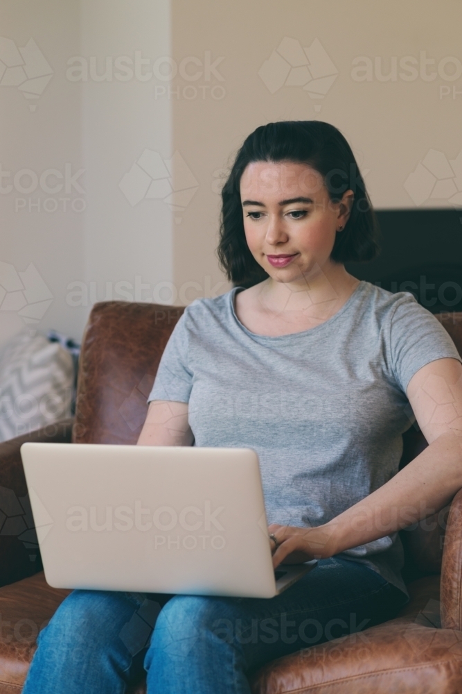 Image of woman using computer at home - Austockphoto